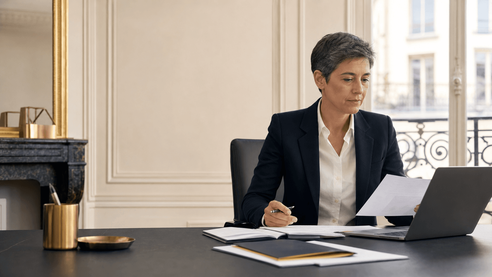 Professionnelle d’une activité réglementée structurant sa présence digitale dans un bureau sobre et rassurant