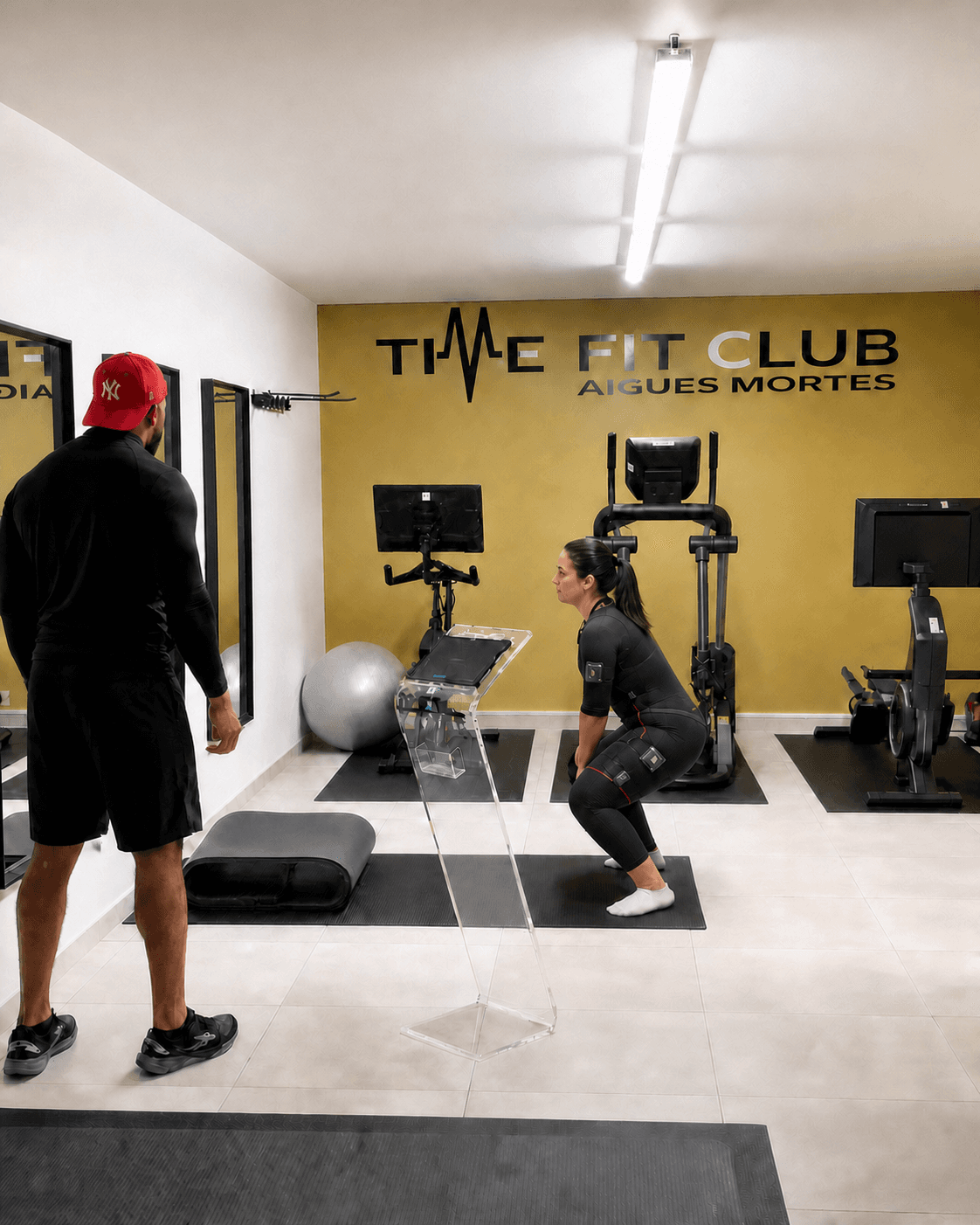 Coach accompagnant une cliente pendant une séance TimeFit